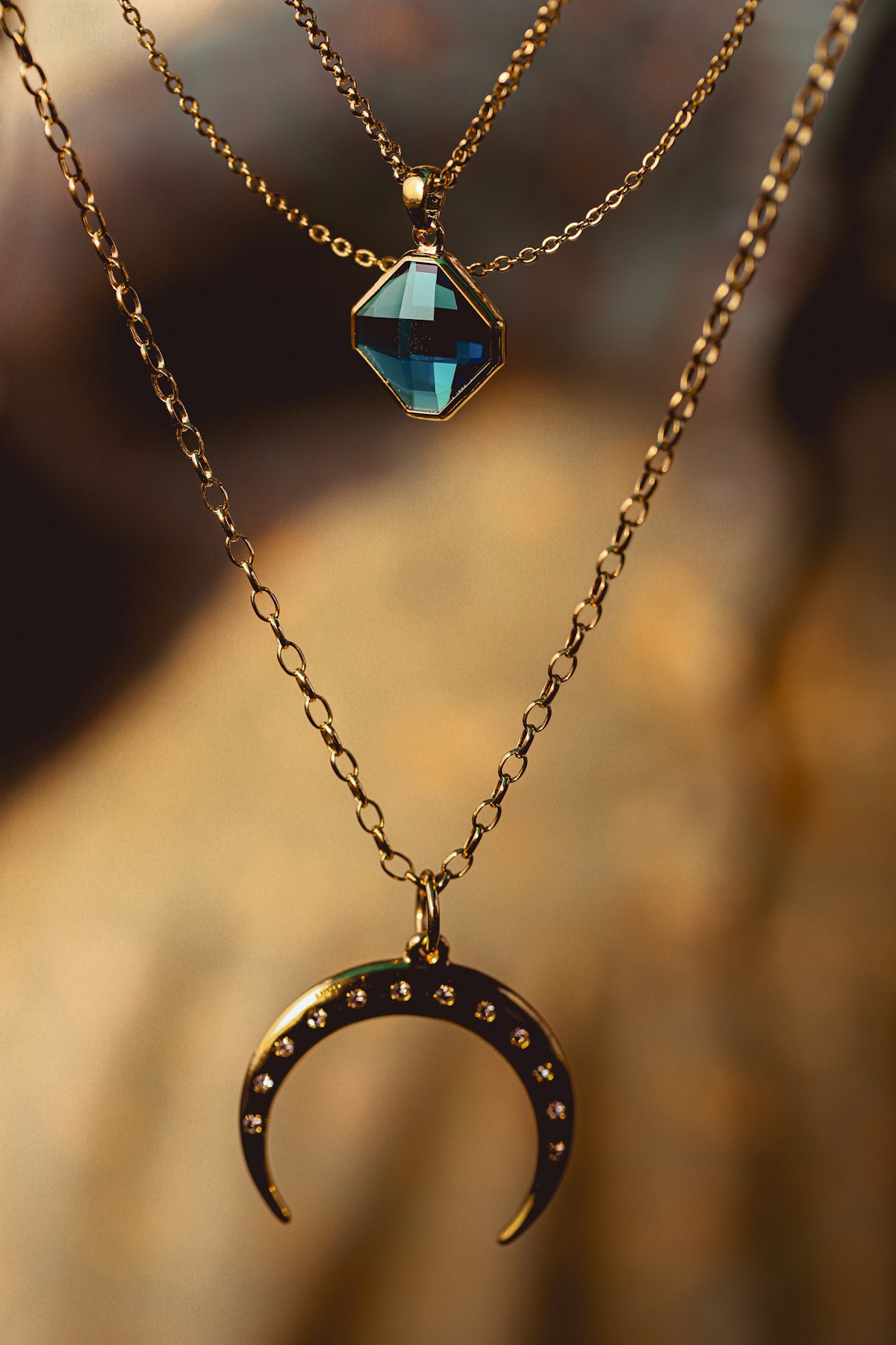 Pendentifs et chaînes dorés avec une pierre bleu profond